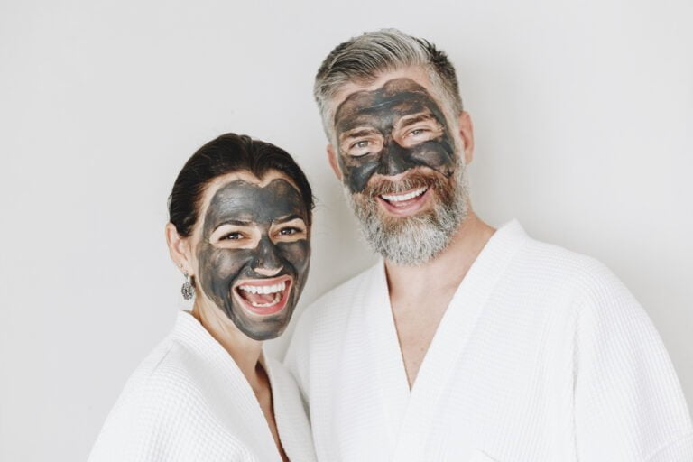 Happy couple wearing a charcoal mask